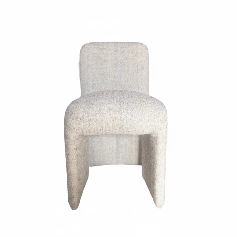 Textured chair in a room with wooden floor and shelves.