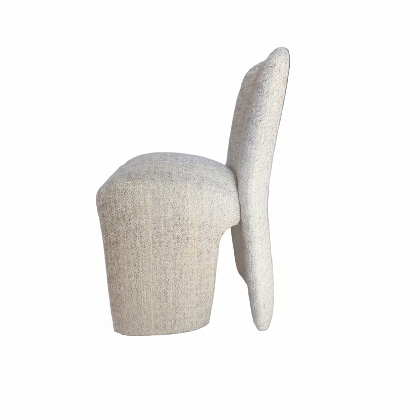 Beige upholstered chair on a wooden floor with a blurred background